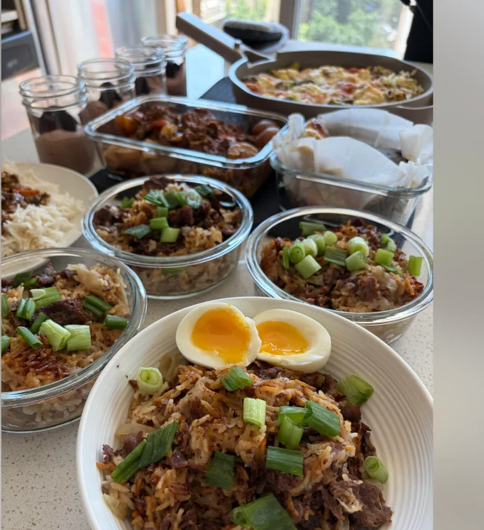 The finished session: glass bowls of gyudon topped with green onions and soft-boiled eggs, beef curry, chicken pesto bake, and desserts in jars